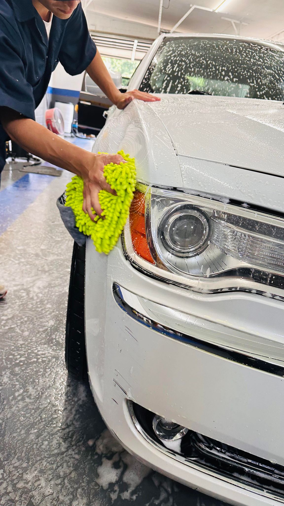 Hands-on exterior cleaning of a white vehicle