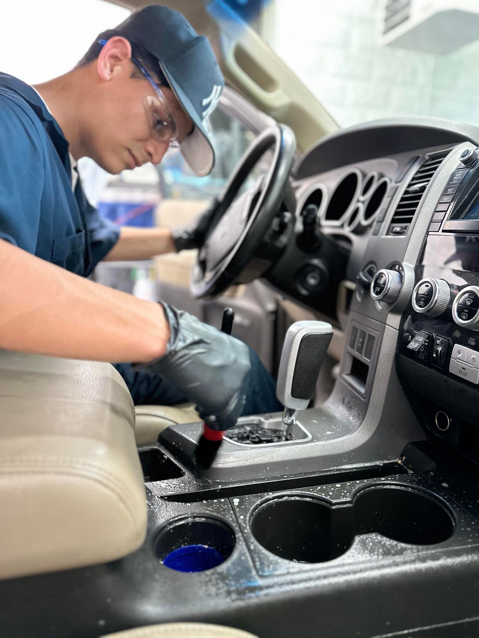 Carefully brushing the center console during an interior detail
